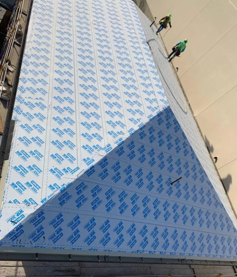 Professional roofers installing underlayment on a metal roof in Paris